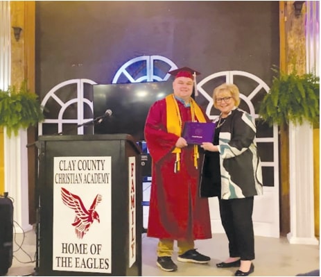 Hope Stockton, assistant vice president for University Outreach and Professional and
Continuing Education, presents Cameron Willis with his graphic design certificate of
completion at his graduation and awards ceremony May 19, 2023, in Ashland, Alabama.